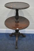 A MAHOGANY TWO TIER DUMBWAITER, with foliate supports, raised on three legs with castors, diameter