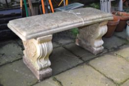 A WEATHERED COMPOSITE RECTANGULAR GARDEN BENCH, on twin scrolled supports, length 100cm x depth 36cm