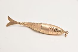 A 9CT GOLD ARTICULATED FISH PENDANT, textured body set with garnet cabochon eyes, fitted with an