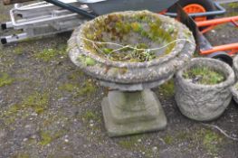A CONCRETE GARDEN URN constructed in two parts with egg and dart rim detail to balustered fluted