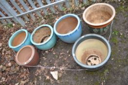 A COLLECTION OF SIX GLAZED PLANT POTS including greens, blues and a brown, the largest being 33cm