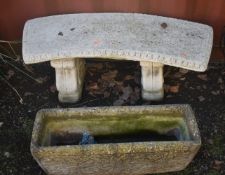 A WEATHERED COMPOSITE CURVED BENCH, on twin scrolled supports, length 110cm, and a rectangular