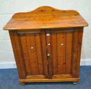 A MODERN PINE DOUBLE DOOR CUPBOARD, with a raised back, raised on turned feet, width 103cm x depth