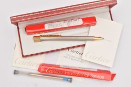 A BOXED 'CARTIER ' BALL POINT PEN, brushed steel pattern with yellow metal clip, signed to the