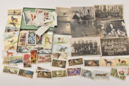 A TIN OF ASSORTED CIGARETTE CARDS AND POSTCARDS, a quantity of various designed cigarette cards in a