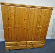 A MODERN PINE FOUR DOOR WARDROBE, with four drawers, width 165cm x depth 53cm x height 180cm,