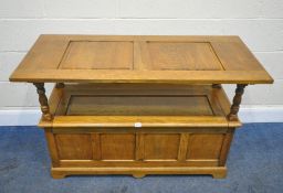 A LATE 20TH CENTURY OAK MONKS BENCH, the tilting surface turns into a backrest, raised on turned