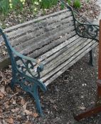 A CAST IRON GARDEN BENCH, with teak slats, length 128cm, condition report: rickety frame,