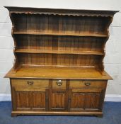 A REPRODUCTION SOLID OAK DRESSER, the two tier plate rack, atop a base with three drawers, over