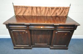 A VICTORIAN MAHOGANY SIDEBOARD, with raised brass supports, for a curtain, fitted with three