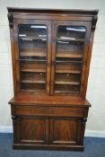 A VICTORIAN MAHOGANY BOOKCASE, the double glass doors enclosing four shelves, atop a base with a