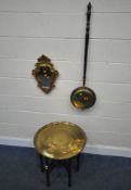 A FOLDING TABLE, with a brass dish top, depicting various repeating patterns, diameter 57cm x height