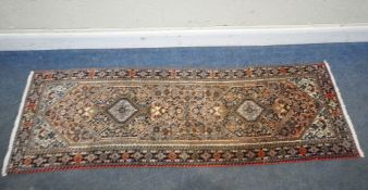 FRITH RUGS, A WOOLEN PERSIAN GOLTUCH RUNNER, with repeating geometric patterns, surrounded by a