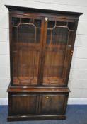 A 20TH CENTURY MAHOGANY BOOKCASE, fitted with double glass doors, atop a base with double cupboard