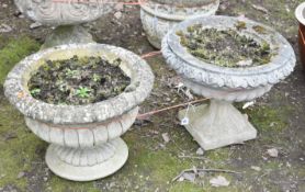 TWO WEATHERED COMPOSITE CAMPAGNA GARDEN URNS, on separate bases, largest diameter 47cm x height