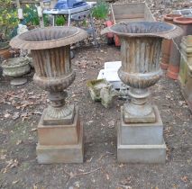 A PAIR OF EARLY 20th CENTURY CAST IRON GARDEN URNS ON STANDS, with fluted detail to bowl, egg and