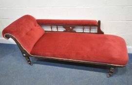 A EDWARDIAN MAHOGANY CHAISE LOUNGE, with burgundy fabric, carved details, raised on turned legs with