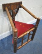 AN EARLY 20TH CENTURY OAK TURNERS CHAIR, with carved geometric designs, turned sloped armrests,