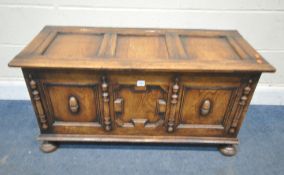 AN EARLY 20TH CENTURY OAK BLANKET CHEST, with geometric panels, raised on bun feet, width 106cm x