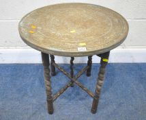 A 20TH CENTURY CIRCULAR FOLDING TABLE, with a brass top, diameter 55cm x height 54cm, condition
