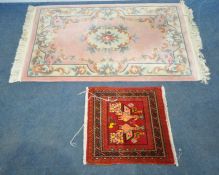 A PINK GROUND CHINESE WOOLLEN RUG, with foliate patterns, 160cm x 93cm, along with a smaller rug,
