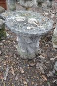 A MODERN CONCRETE GARDEN SEAT, in the form of a tree stump with a ringed round plank for a top,