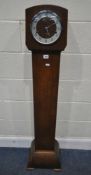 AN ART DECO OAK GRANDDAUGHTER CLOCK, with an arched hood, the convex glass door enclosing a 7 inch