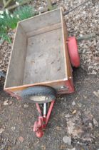 A SMALL TRAILER, with wooden slatted sides, one axle and towing hitch, bed width 76cm, length 122cm
