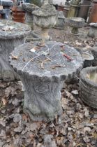 A MODERN CONCRETE GARDEN SEAT, in the form of a tree stump with a ringed round plank for a top,