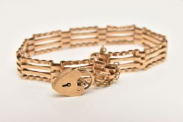 A 9CT GOLD GATE BRACELET, a yellow gold four bar gate bracelet, fitted with a heart padlock clasp,