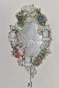 A SITZENDORF PORCELAIN CANDELABRA MIRROR with a moulded floral frame with a figure of a cherub to