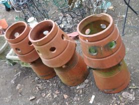 A SET OF THREE TERRACOTTA CHIMNEY POTS, with double tapered round design, heights 71cm. Condition