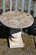 A WEATHERED COMPOSITE GARDEN TABLE, with foliage detail to the top surface, on a bulbous support,