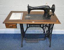 A 20TH CENTURY TREADLE SINGER SEWING MACHINE, with a cast iron base, and a single drawer, width 99cm