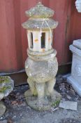 AN ORIENTAL CONCRETE GARDEN ORNAMENT, in the form of a pagoda sat atop an orb with dragon detail and