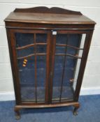 AN EARLY 20TH CENTURY OAK DISPLAY CABINET, with double glazed doors, enclosing two glass shelves,