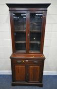 AN EARLY 20TH CENTURY MAHOGANY BOOKCASE, the double glazed doors enclosing three adjustable shelves,