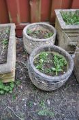 A PAIR OF ROUND CONCRETE PLANTERS, with diagonal fluting and foliate detailing, 36cm in diameter (