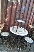 A MODERN GARDEN TABLE AND FOUR CHAIRS, with tubular metal frames and geometric patterned tiled
