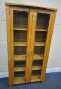 A MODERN BOOKCASE, with double glass doors, that are enclosing four shelves, width 90cm x depth 40cm