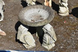 A WEATHERED COMPOSITE BIRD BATH, raised on triple supports of a mythical bird, diameter 48cm x