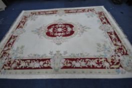 A LARGE CREAM GROUND WOOLLEN RECTANGULAR RUG, with a central medallion, surrounded by a multi-