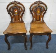 A PAIR OF EARLY 20TH CENTURY OAK HALL CHAIRS, the backrests with scrolled and foliate details,
