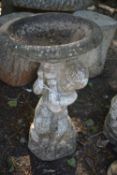 A WEATHERED COMPOSITE BIRD BATH, on a separate cherub figure, diameter 38cm x height 63cm, condition