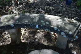 A WEATHERED COMPOSITE CURVED BENCH, on a pair of scrolled supports, length 135cm, condition