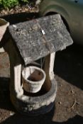 A WEATHERED COMPOSITE WISHING WELL, with a tiled effect canopy roof and hanging bucket, width 58cm x