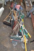 A QUANTITY OF GARDEN TOOLS, including shovels, spades, forks, rakes, brushes, hoes, etc