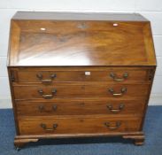 A GEORGIAN MAHOGANY BUREAU, the fall front door enclosing a fitted interior, over four graduated