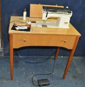 A SINGER FUTURA SEWING MACHINE, with pedal, power cable mounted in a teak cabinet (PAT fail due to