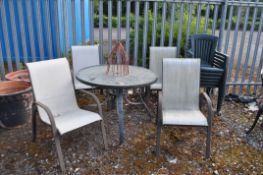 A GLASS TOPPED METAL FRAMED GARDEN TABLE four similar chairs and six green plastic garden chairs